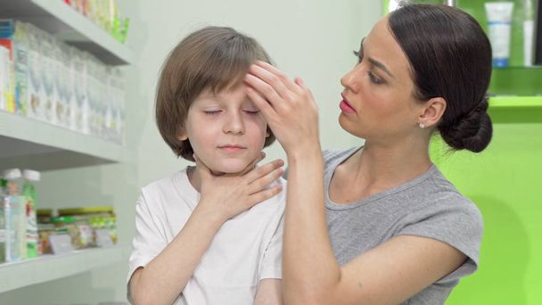 Beautiful woman looking disturbed as her little son coughing and having fever - Photo, Image