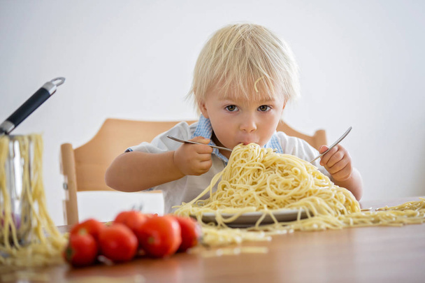 Little baby boy, toddler child, eating spaghetti for lunch and m - Photo, Image