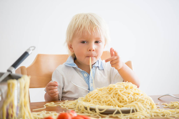 Little baby boy, toddler child, eating spaghetti for lunch and m - Фото, изображение