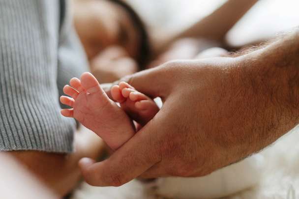 Parent holding in the hands feet of newborn baby. - Фото, зображення