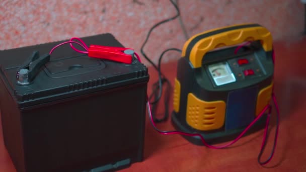 Car battery with two jumpers fixed to the terminals. Battery Charger. Car preparation for winter - Footage, Video