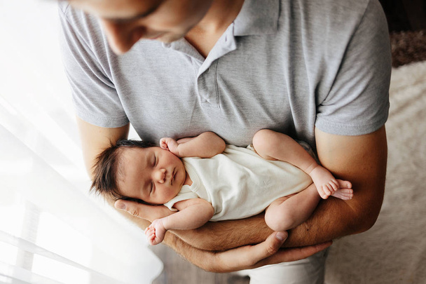Father holding newborn baby. Portrait of a newborn girl closeup. Father and daughter - Foto, afbeelding
