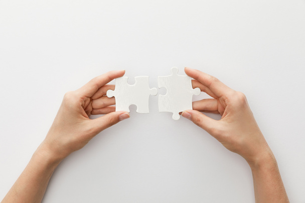 cropped view of woman holding piece of jigsaw puzzle on white background - Photo, Image