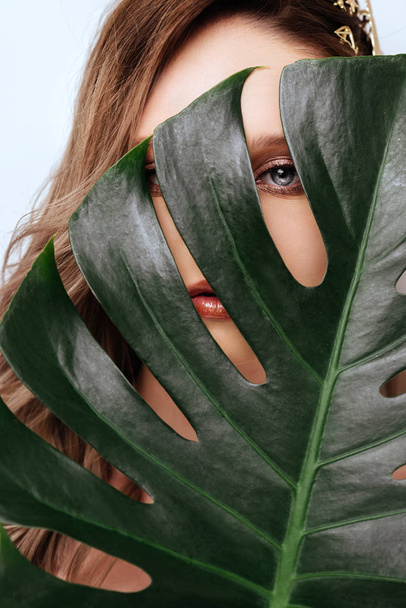 Portrait of young and beautiful woman in tropical leaves. - Photo, image