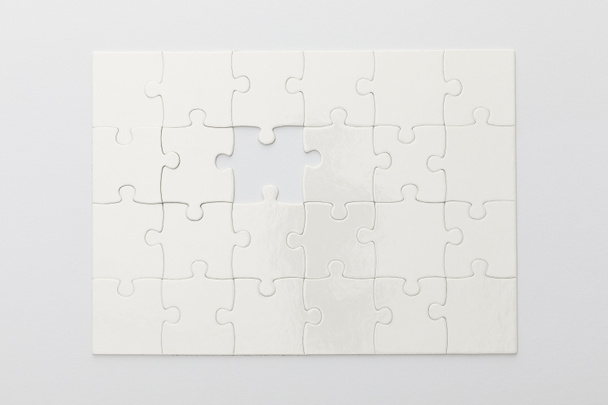 Draufsicht des fertigen Puzzles ohne ein Teil auf weißem Hintergrund - Foto, Bild