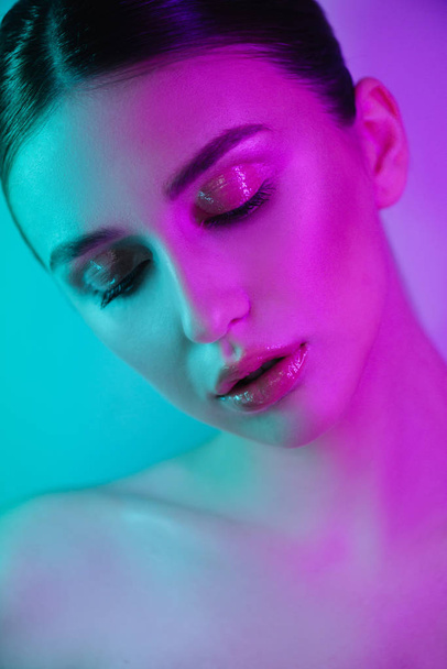High Fashion woman in colorful bright neon uv blue and purple lights, posing in studio - 写真・画像