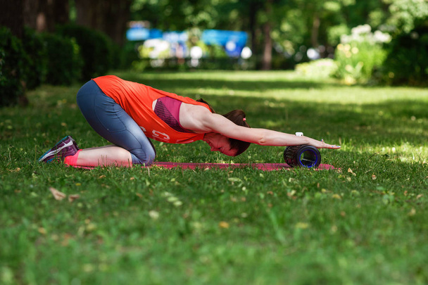 Молодая красивая женщина медитирует в летний день в парке
. - Фото, изображение