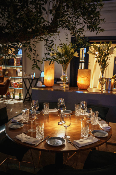 сервированный стол с пустыми стаканами в интерьере ресторана
 - Фото, изображение