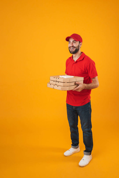 Full length portrait of handsome delivery man in red uniform smi - Φωτογραφία, εικόνα