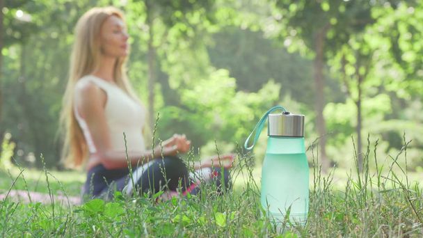 Frau meditiert im Park auf dem Rasen - Foto, Bild
