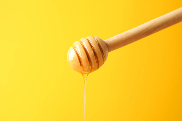 Contagocce con miele su sfondo giallo, spazio per testo
 - Foto, immagini