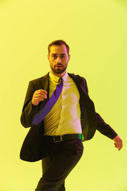 Image of caucasian serious businessman in formal suit gesturing while walking - 写真・画像