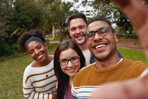 Multi ethnic people enjoying time together and taking selfie in the park - Foto, Bild