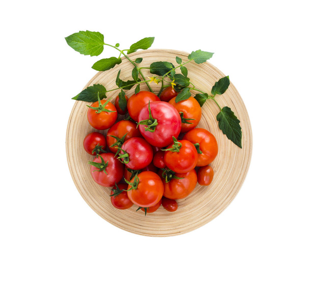 Holzschale mit verschiedenen reifen Tomaten auf weißem Hintergrund. - Foto, Bild