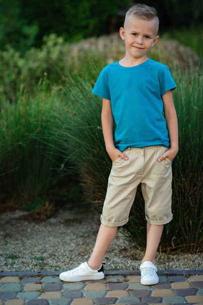 Retrato de un niño rubio posando afuera
 - Foto, imagen