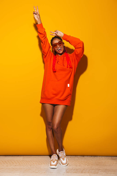 Image of happy african american woman wearing sunglasses and hoo - Fotó, kép