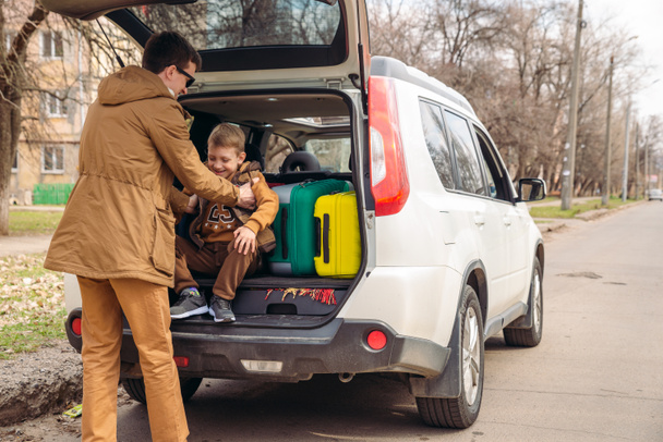 padre con figlio fare le valigie al bagagliaio auto. concetto di viaggio in auto
 - Foto, immagini