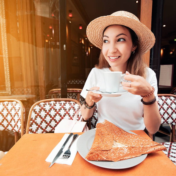 Woman having breakfast with traditional french crepes galette - baked pancakes with cheese filling - Photo, Image