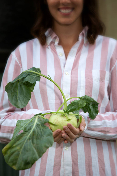 νεαρή μελαχρινή γυναίκα που κρατά ένα γογγύλι λάχανο - Φωτογραφία, εικόνα