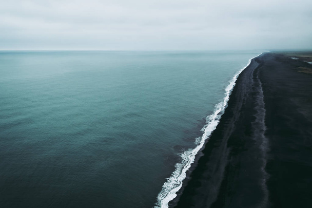 Výhled od majáku Dyrholaey na Islandu. Pláž s černým pískem, bílá pěna a modrá voda v Atlantickém oceánu - Fotografie, Obrázek