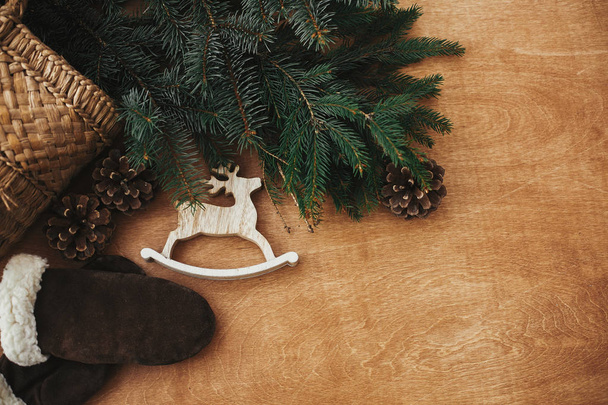 Ahşap reindeer oyuncak, eldiven, köknar dalları ve konileri ile sepet  - Fotoğraf, Görsel