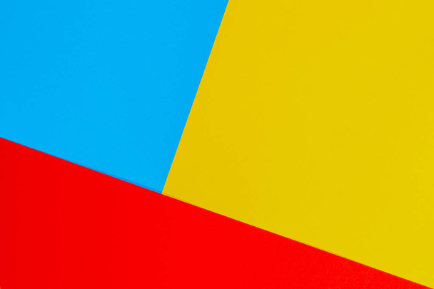 Color papers geometry flat composition background with yellow red and blue tones - Foto, afbeelding