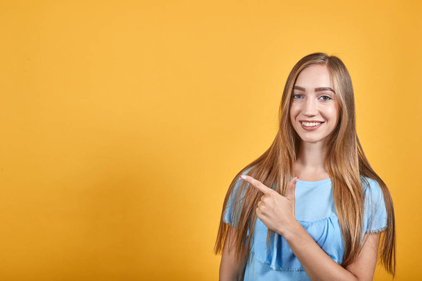 Tyttö brunette sininen t-paita yli eristetty oranssi tausta osoittaa tunteita
 - Valokuva, kuva