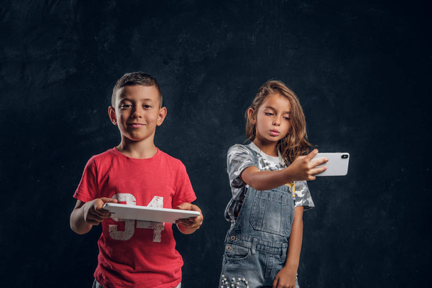 Portret zabawnych dzieci z urządzeniami elektronicznymi - Zdjęcie, obraz