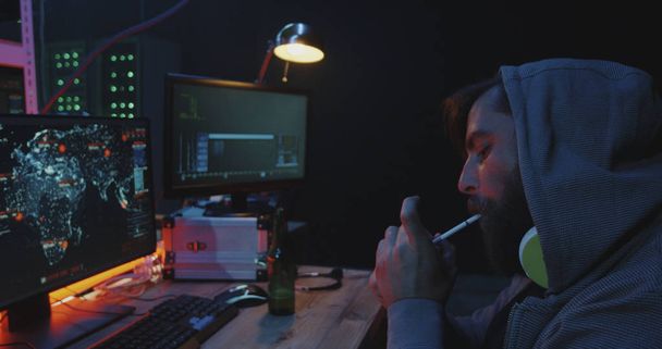 Hacker smoking and spreading computer virus - Photo, Image