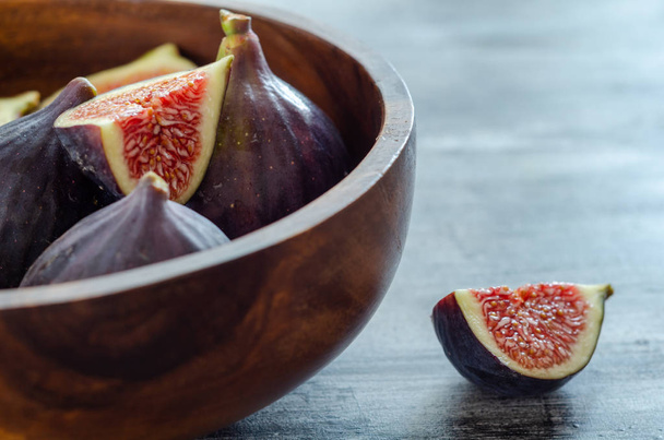 Dojrzałe figowe owoce są w drewnianej misce  - Zdjęcie, obraz