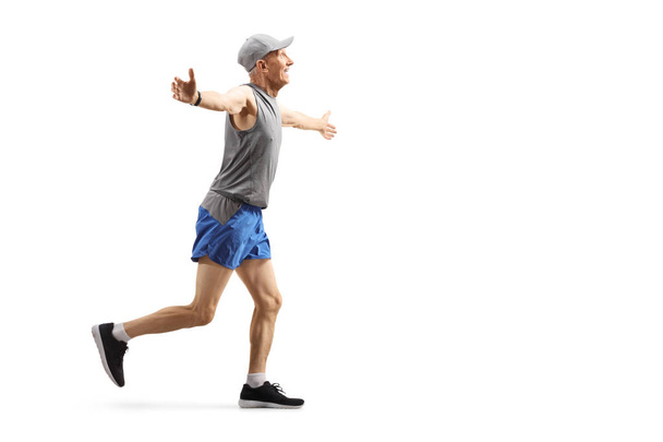 Senior man running and spreading arms - Фото, зображення