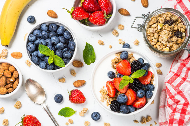 Greek yogurt granola with fresh berries on white table. - Фото, изображение