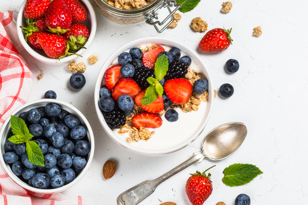 Greek yogurt granola with fresh berries on white table. - Photo, Image