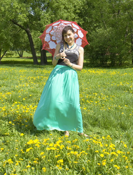 黄色のタンポポの牧草地に日傘を持つ女性 - 写真・画像
