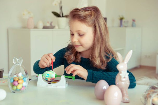 Cute little blonde girl painting Easter eggs - Foto, afbeelding
