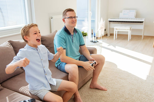 幸せな若い父親と彼の息子は、詐欺でコンピュータゲームをプレイ - 写真・画像