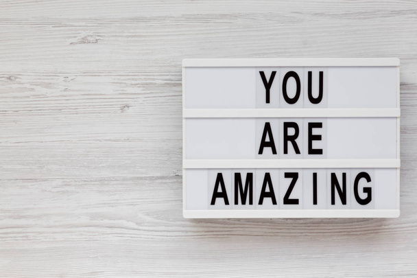 'Eres increíble' palabras en un tablero moderno en una espalda de madera blanca
 - Foto, Imagen
