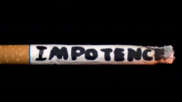 Savukkeenkyljyksiä, joissa lukee "Impotenssi". Savuke mustalla, eristetyllä taustalla. Terveysvaara - Materiaali, video