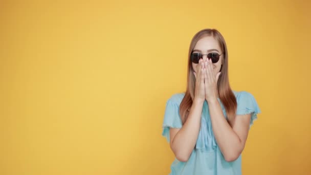 girl brunette in blue t-shirt over isolated orange background shows emotions - Πλάνα, βίντεο