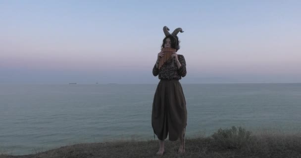 Κορίτσι με κέρατα από ένα βουνίσιο κατσίκι σε φόντο της θάλασσας. - Πλάνα, βίντεο
