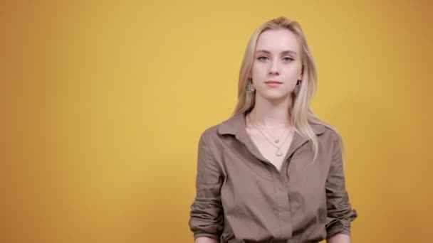 izole turuncu arka plan üzerinde kahverengi bluz sarışın kız duyguları gösterir - Video, Çekim