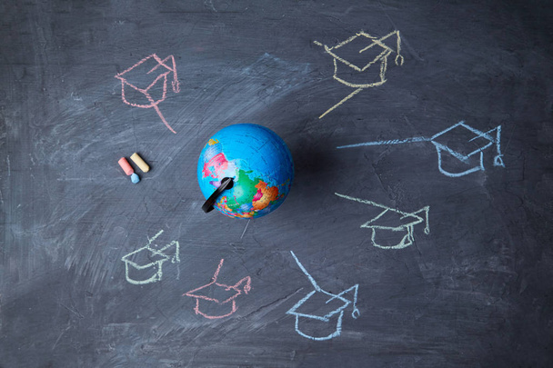Global online education and e-learning. Webinar and language school. Globe, and symbols graduate caps - Photo, Image