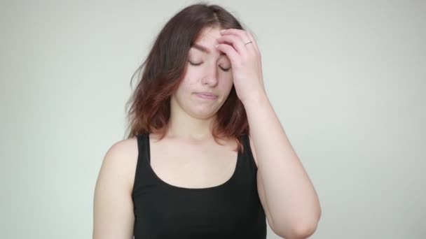 mooi meisje in zwarte tank top over geïsoleerde witte achtergrond toont emoties - Video