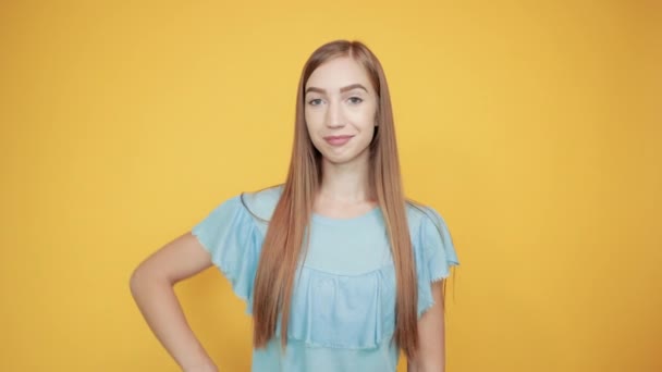 Mädchen Brünette in blauem T-Shirt über isoliertem orangefarbenem Hintergrund zeigt Emotionen - Filmmaterial, Video