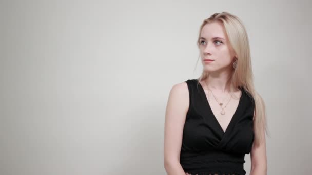 blonde fille dans une robe noire sur fond blanc isolé montre des émotions
 - Séquence, vidéo