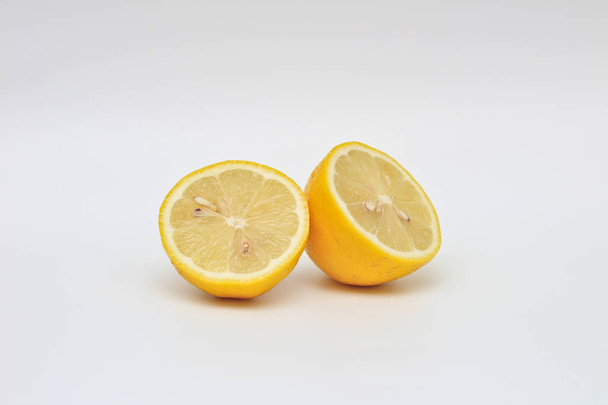 Fresh, ripe, isolated, juicy bisected lemon on a white background. Studio macro shoot - Foto, Imagen