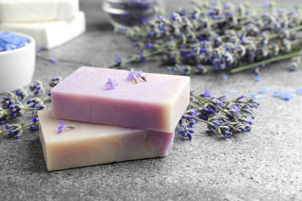 Hand made soap bars with lavender flowers on grey stone table. Space for text - Foto, imagen