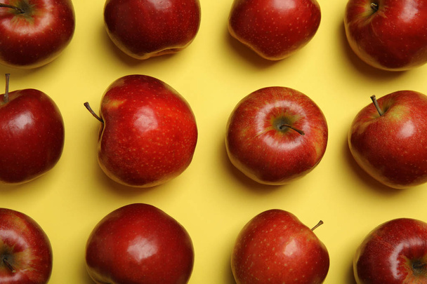 Flat lay composition with ripe juicy red apples on yellow background - Фото, изображение