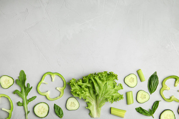 Flat lay composition with fresh salad ingredients on grey background, space for text - Foto, Bild