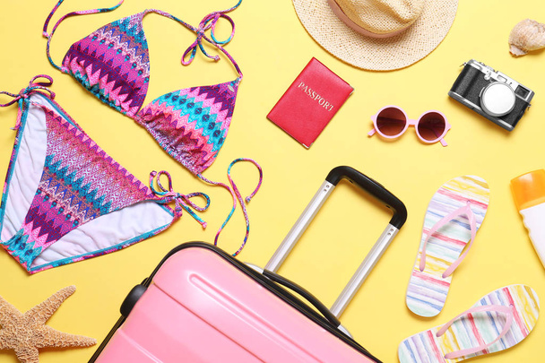 Flat lay composition with suitcase and beach objects on yellow background - Zdjęcie, obraz